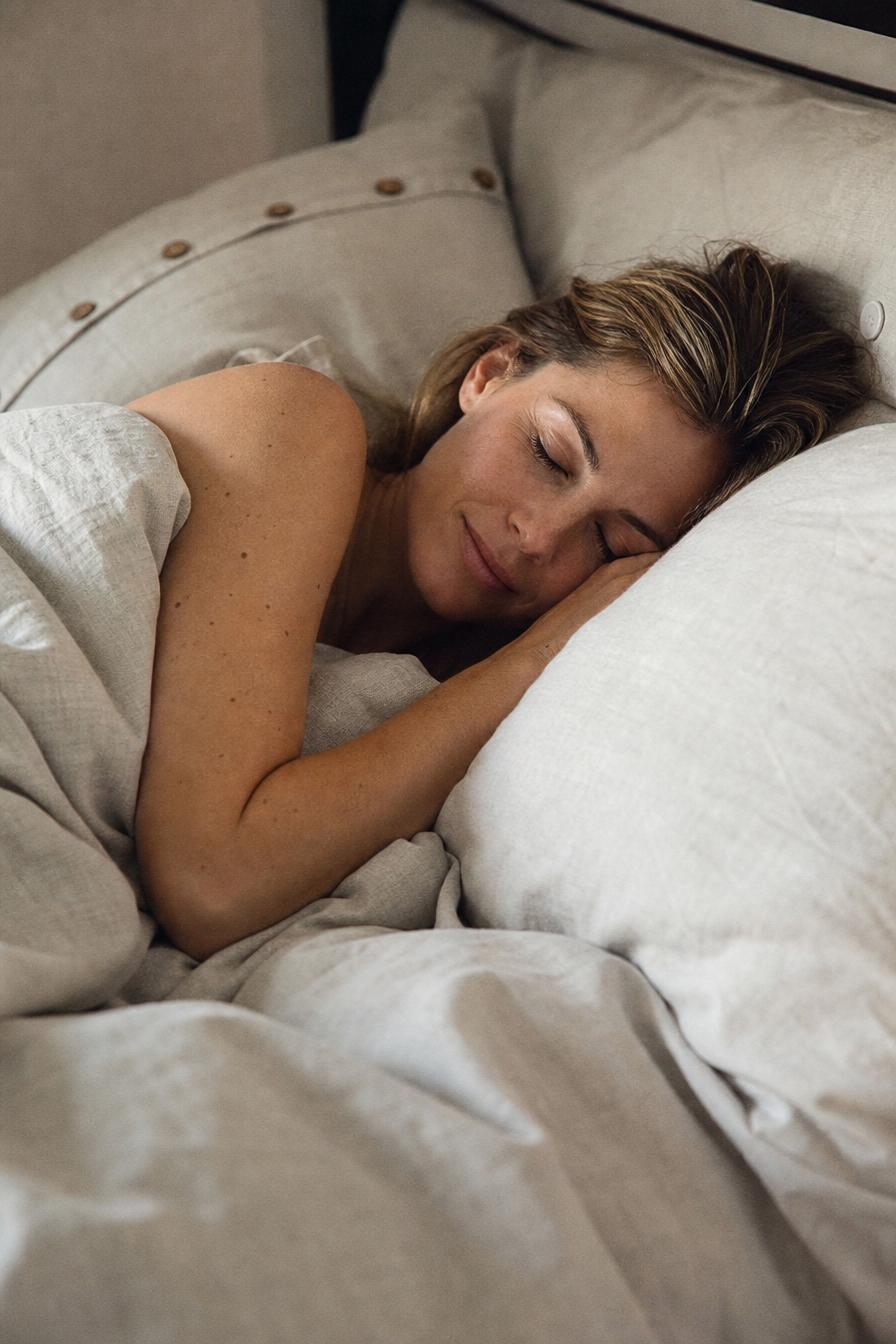 Woman sleeping peacefully in a cozy bed